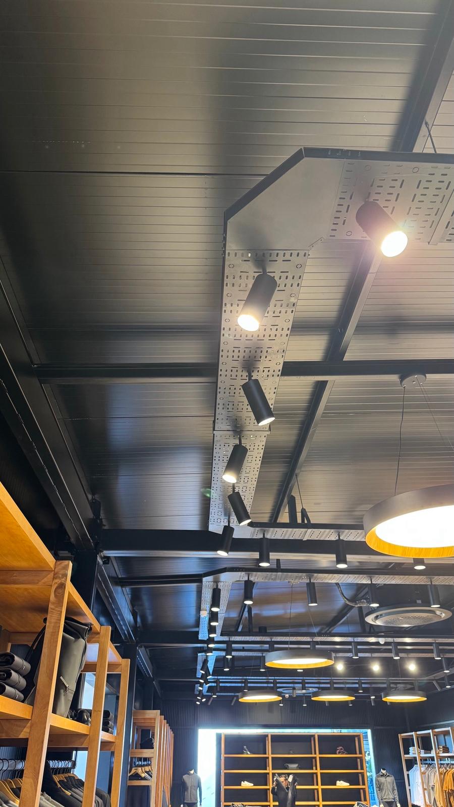 Interior de local con techo de panel negro PanelYA